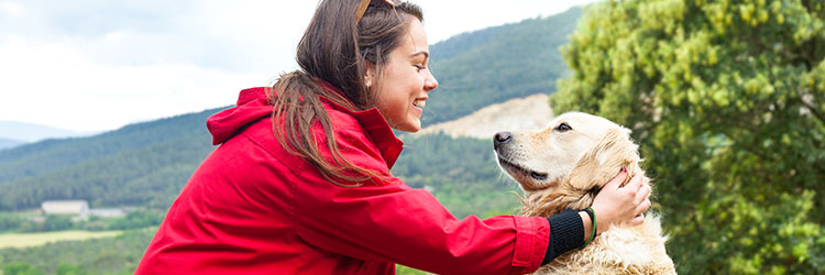 Woman petting her Golden Retriever in the park